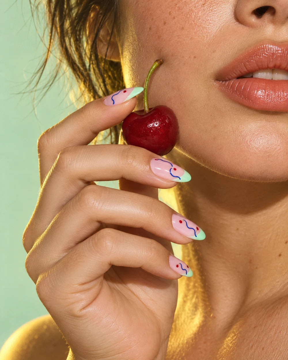 Playful blue and mint nail art with a cherry — concept photography